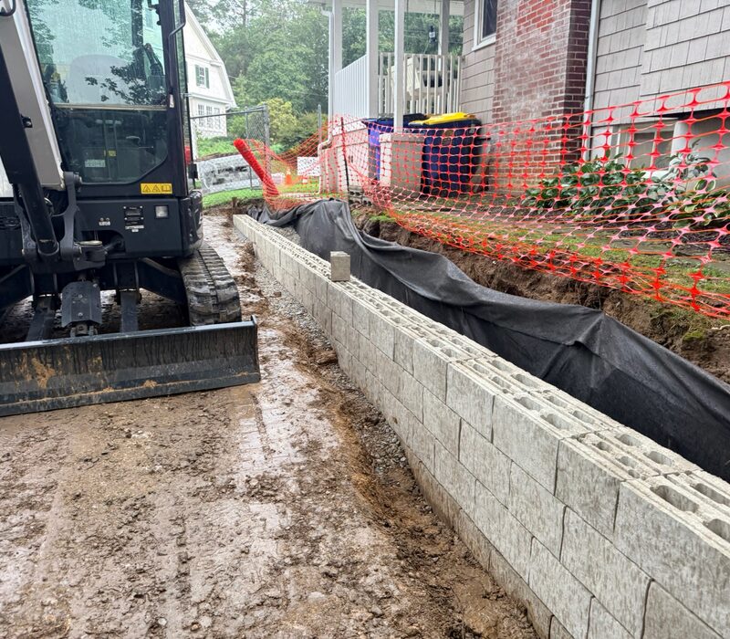 Retaining wall installation with geotextile fabric for wall drainage