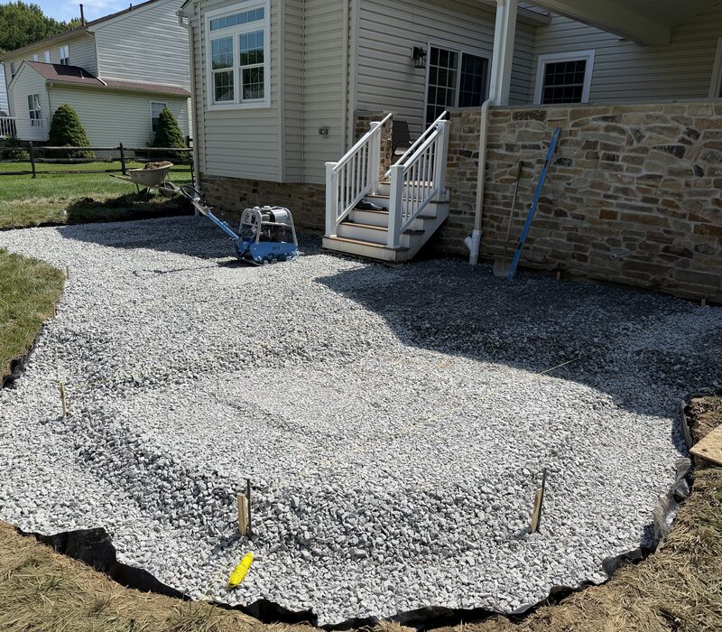 Compacted gravel base extending past the paver patio edges
